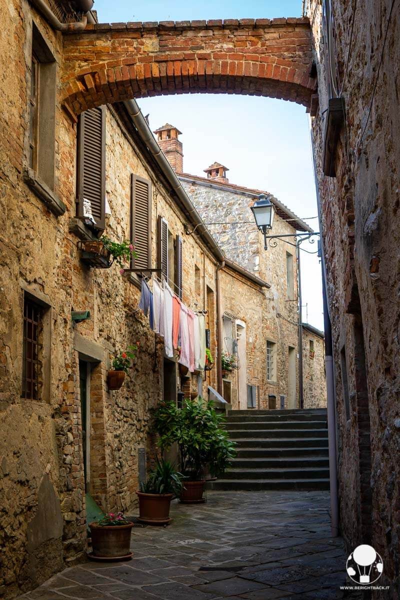 Vicolo medievale con arco e panni stesi, Lucignano